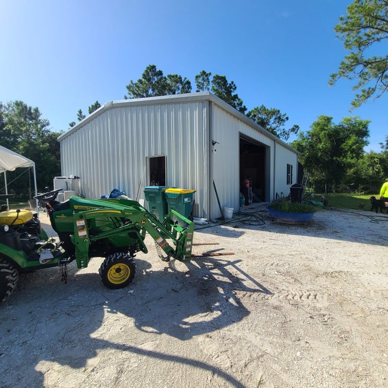 White Steel Garage with Green Tractor