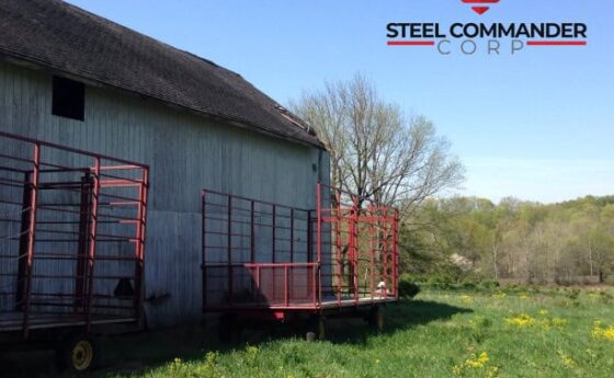 Prefab steel storage building with red ramps in rural setting.