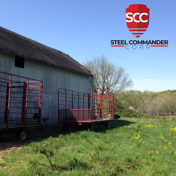 Prefab steel storage building with red ramps in rural setting.