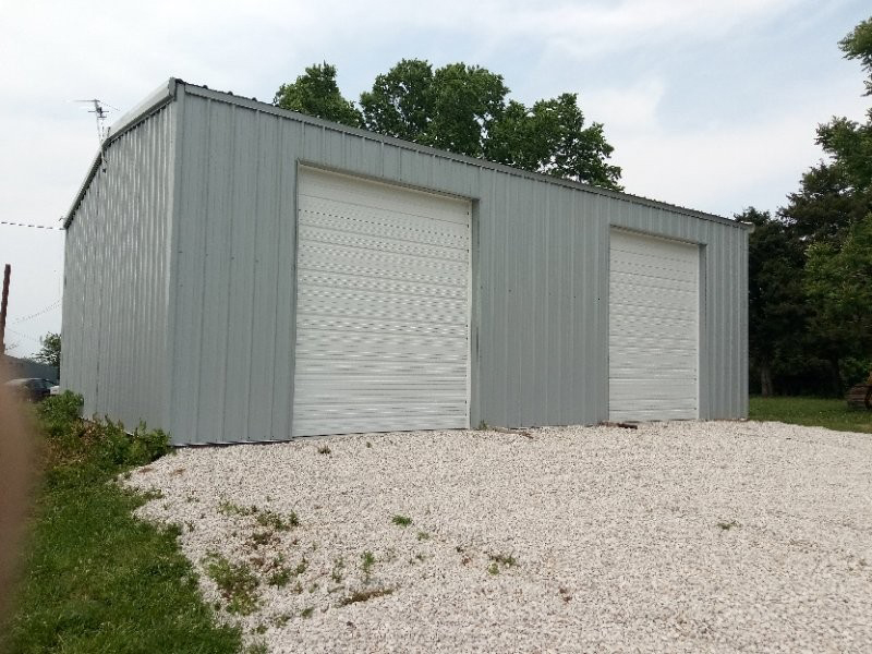 Gray Steel Garage with White Roll Up Doors