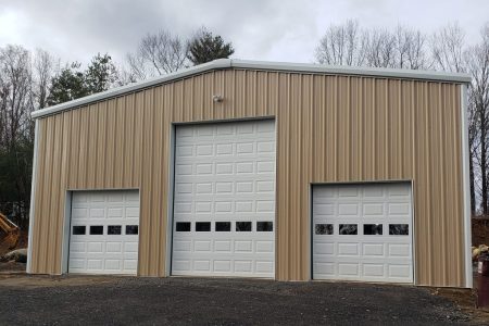 Steel garage building with three roll-up doors, ideal for storage and vehicle protection. Steel Commander Corp logo — American prefab steel building manufacturer, Boca Raton, Florida