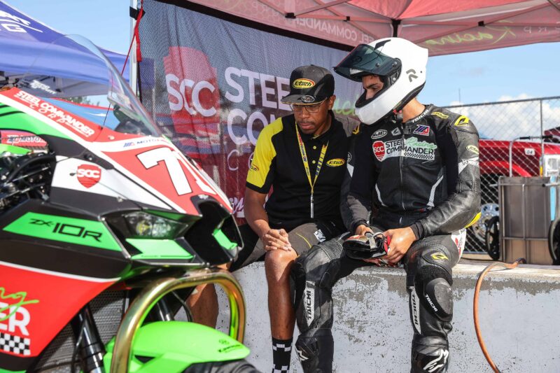 Kawasaki racing motorcycle at Brainerd Motorsports Park with team members.