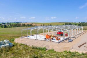 Steel Commander racing team building under construction in open field.