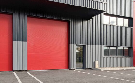 Steel building garage for commercial storage. Prefab steel commercial warehouse with loading dock doors and metal roof — rigid frame construction.