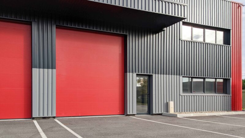 Steel building garage for commercial storage. Prefab steel commercial warehouse with loading dock doors and metal roof — rigid frame construction.